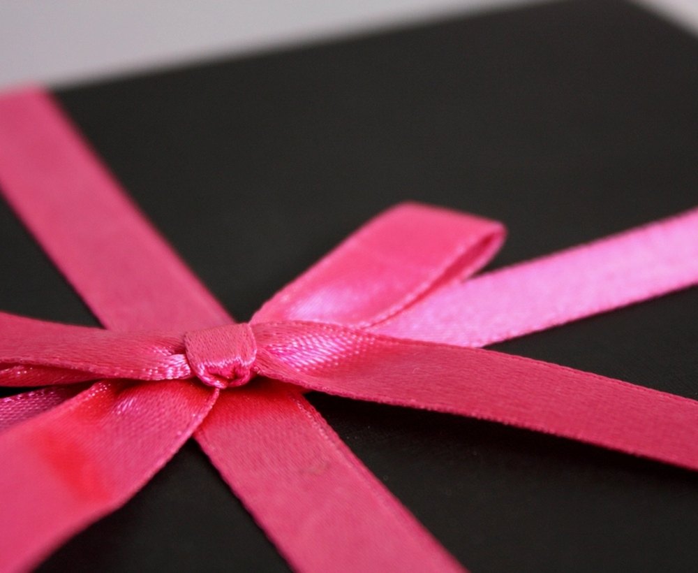 A gift box tied with a pink satin ribbon